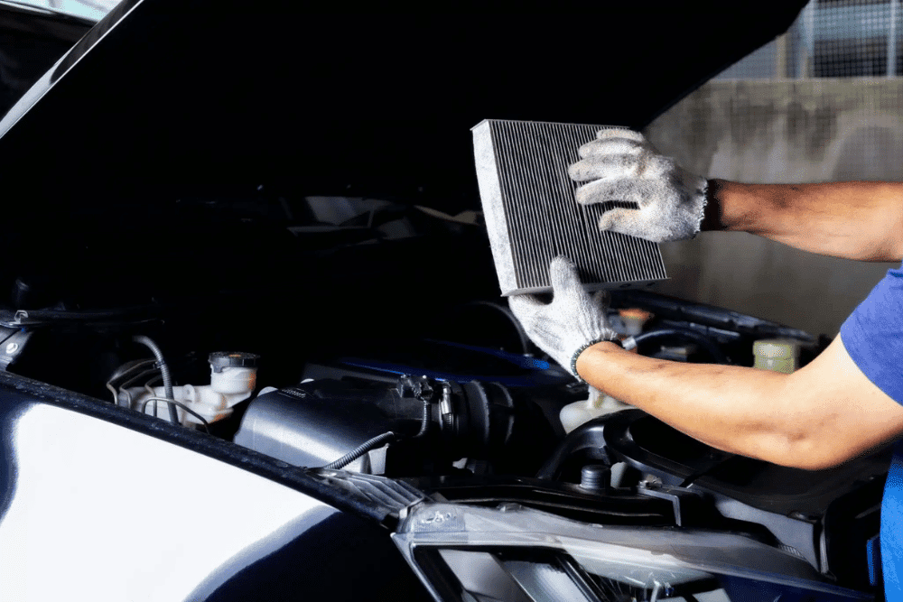 preventative maintenance during national car care month in Springboro, OH by Springboro Automotive -- a mechanic inspects a car's air filter during routine maintenance
