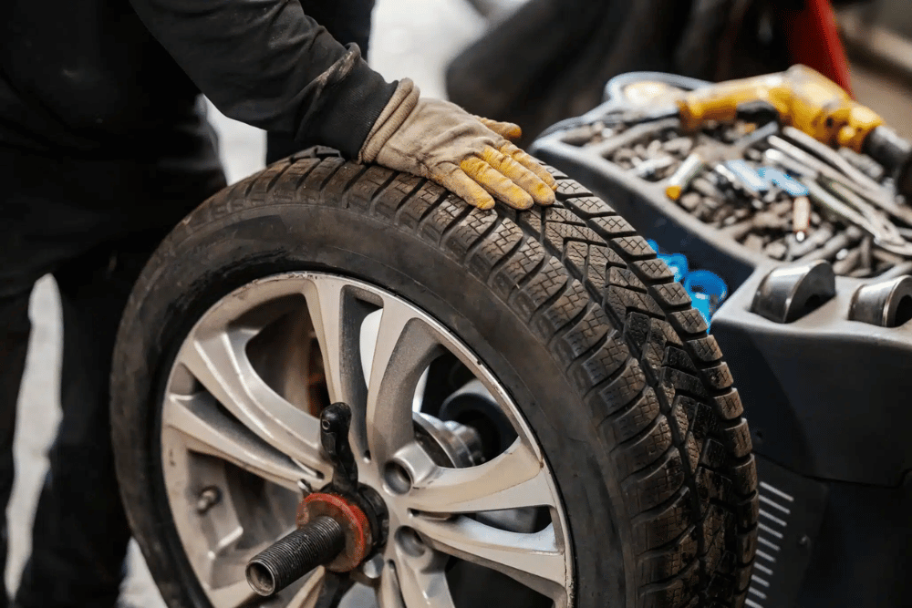 Tire Rotation and Balancing by Springboro Automotive, a mechanic inspecting a tire